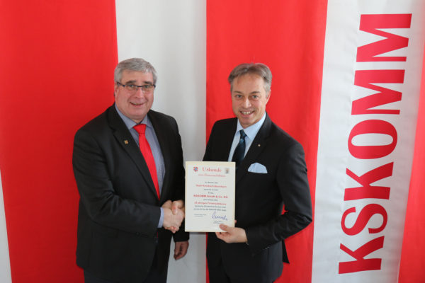 Michael Merz gratuliert Klaus Stukemeier, Geschäftsführer der KSKOMM GmbH & Co. KG, zum 25-jährigen Firmenbestehen und überreichte zu diesem Anlass eine Urkunde.
