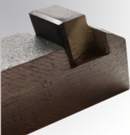 PKD-Schneideinsätze für Abisoliermesser aus Jena: Die definierten PKD-Schneiden werden mit keramischen Diamantschleifscheiben geschliffen und erzeugen scharfe Schneiden, die trotzdem robust sind und keine Schartigkeiten in der Mikrogeome­‑trie aufweisen.