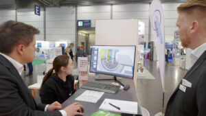 Unter den Augen von Marcus Matthäi, Head of Machine Demonstration (li.), und Eduard Kleinschmidt, Application Technican (beide Adelbert Haas GmbH) programmiert Angelina Obele ihren Fräser.