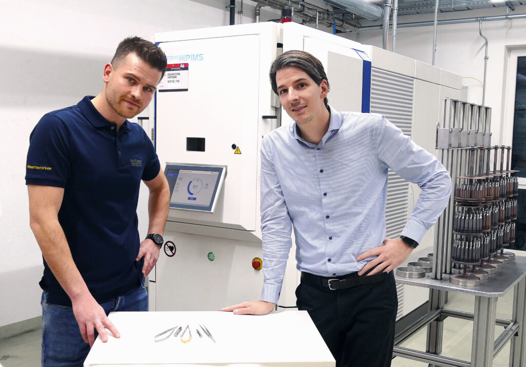 Jan Alber (links), Produktionsleiter bei MICROMA, und Martin Seifriz (rechts), Geschäftsführer bei NACHREINER, vor der HiPIMS-Beschichtungsanlage in der NACHREINER Produktion.